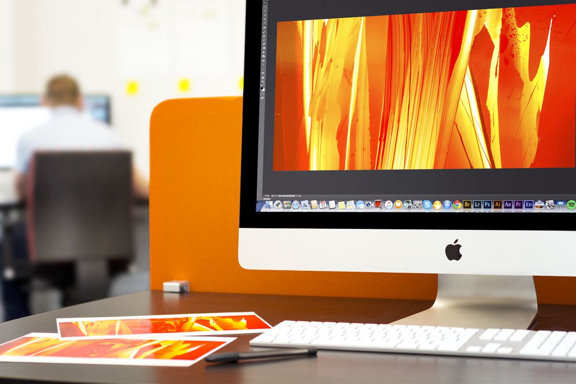 A computer with an orange patterned graphic on it. On a desk is an orange patterned graphic.